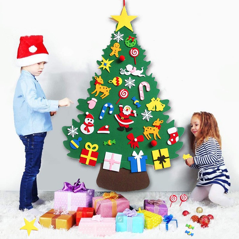 Toddler decorating a Pinelet felt Christmas tree on the wall